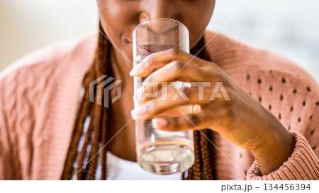 Refreshing Drink. Beautiful Young Black Lady Drinking Water From Glass At Home, Enjoying Clean Mineral Liquid While Relaxing In Kitchen, Taking Healthy Beverage For Body Hydration, Closeup, Cropped 134456394