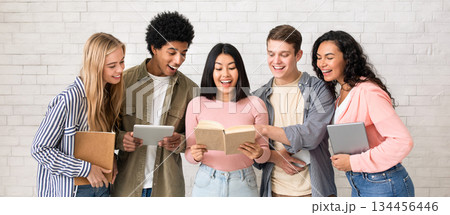 Youth lifestyle and friendship, teamwork and study in college or university. Surprised asian young lady found information, friends hold gadgets and look at book in classroom, studio shot, empty space Youth lifestyle and friendship, teamwork and study in college or university. Surprised asian young lady found information, friends hold gadgets and look at book in classroom, studio shot, empty space 134456446