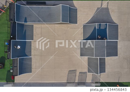 Skatepark aerial view with bmx riders on ramps 134456843