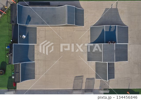 Aerial view of skatepark with bmx rider on concrete ramp 134456846