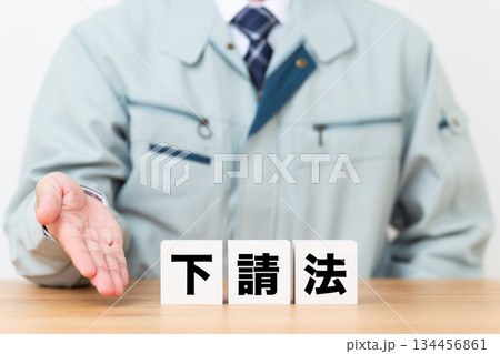 下請法のブロックと作業着を着たミドル男性ビジネスマン 下請法のブロックと作業着を着たミドル男性ビジネスマン 134456861