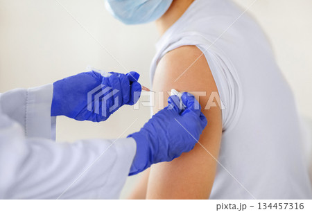 Cropped view of young male patient receiving injection of coronavirus vaccine at clinic, closeup. Unrecognizable doctor immunizing millennial man against covid-19 virus. Healthcare and medicine Cropped view of young male patient receiving injection of coronavirus vaccine at clinic, closeup. Unrecognizable doctor immunizing millennial man against covid-19 virus. Healthcare and medicine 134457316