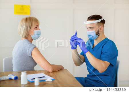 Senior Caucasian woman having covid-19 vaccine injection at hospital. Mature lady receiving coronavirus immunization at clinic. Medical care and health services concept Senior Caucasian woman having covid-19 vaccine injection at hospital. Mature lady receiving coronavirus immunization at clinic. Medical care and health services concept 134458289