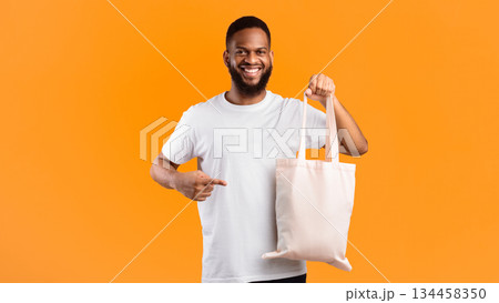 No More Plastic. Smiling Black Guy Holding Textile Eco Bag Standing Over Yellow Background In Studio. Ecology And Consumerism, Eco-Friendly Plastic-Free Lifestyle Concept. Panorama 134458350