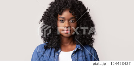 Closeup portrait of beautiful african american millennial woman in casual with curly hair posing on grey studio background, copy space. Feminine beauty concept, women diversity 134458427
