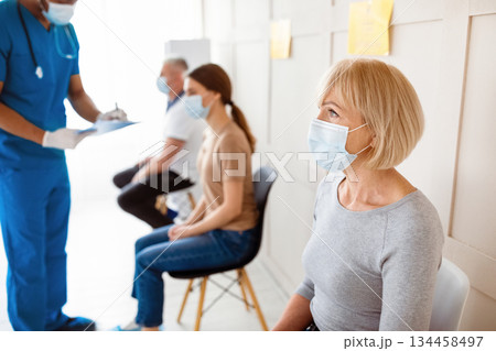 Senior woman waiting for covid-19 vaccine injection, doctor checking patients' health before immunization at clinic. Coronavirus vaccination, protection against viral diseases campaign 134458497