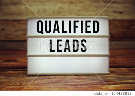 Lightbox with text "Qualified Leads" on wooden background 134458812