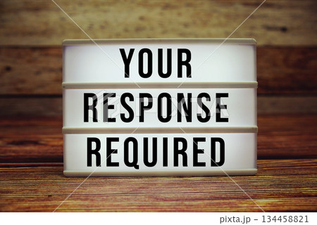 Lightbox with text "Your Response Required" on wooden background 134458821