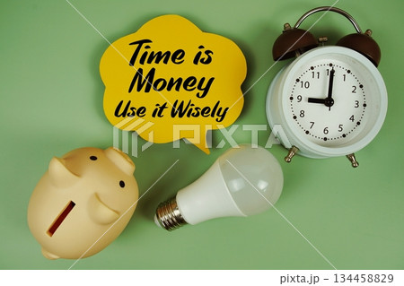 Time is Money, Use it Wisely text written on speed bubble with light bulb, piggy bank and alarm clock 134458829