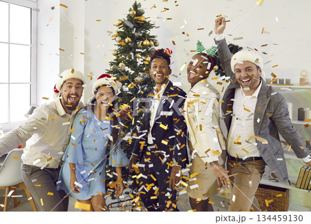 Positive colleagues having fun, laughing and throwing confetti at New Year corporate party in office Positive colleagues having fun, laughing and throwing confetti at New Year corporate party in office 134459130