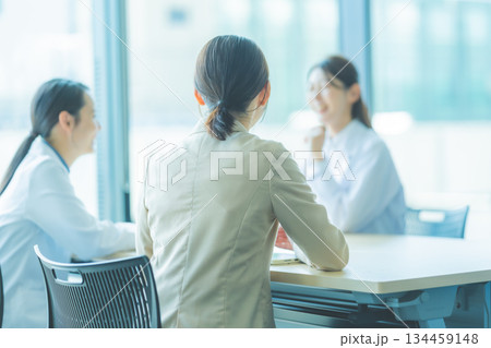 会議室で笑顔で対話する女性医師とスタッフ 134459148