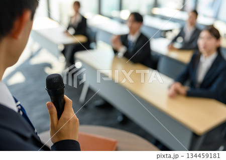 マイクを持つ講師と研修を受ける社員 134459181