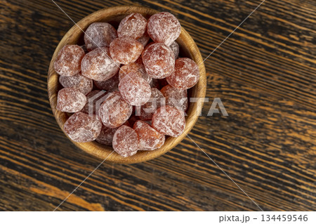 small fruits of fragrant kumquat dried in sugar syrup, food details, round dehydrated kumquat fruit in a wooden bowl small fruits of fragrant kumquat dried in sugar syrup, food details, round dehydrated kumquat fruit in a wooden bowl 134459546