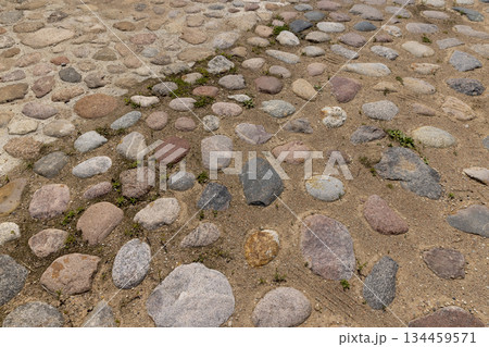 a road made of stones of different sizes in rural areas, a reconstructed ancient road made of multicolored cobblestones and pebbles a road made of stones of different sizes in rural areas, a reconstructed ancient road made of multicolored cobblestones and pebbles 134459571