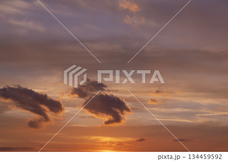 multi-colored sunset with different colors and clouds as the sun sets over the horizon, multi-colored sky with warm colors and a touch of sunset or sunrise 134459592