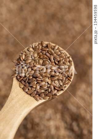 flax seeds in a wooden spoon, a wooden spoon filled with fresh flax seeds flax seeds in a wooden spoon, a wooden spoon filled with fresh flax seeds 134459598