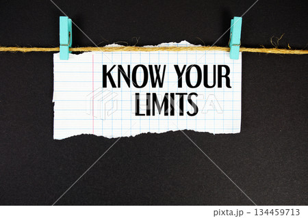 Know Your Limits text written on rip paper with wooden clip on black background 134459713