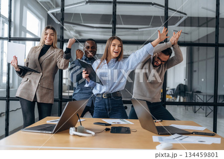 Smiling, celebrating success. Professional workers are in the modern office together Smiling, celebrating success. Professional workers are in the modern office together 134459801