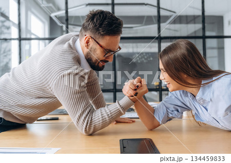 Office workers are having fun and doing arm wrestling 134459833