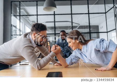 Fun times. Office workers are doing arm wrestling Fun times. Office workers are doing arm wrestling 134459834