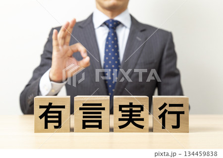 「有言実行」と書かれたブロックとOKポーズをするビジネスマン 「有言実行」と書かれたブロックとOKポーズをするビジネスマン 134459838
