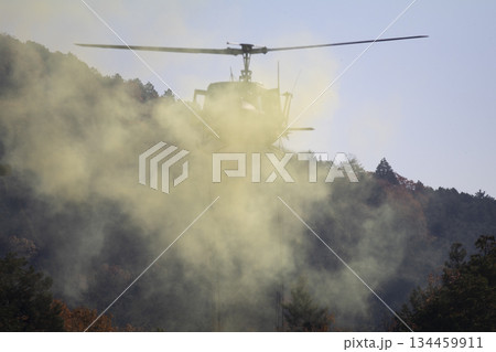 煙の中飛ぶヘリコプター 134459911