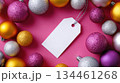 Colorful Christmas decorations surround a blank gift tag on a vibrant pink background 134461268