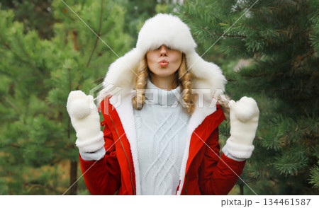 Winter portrait of happy smiling woman having fun enjoys snow against Christmas tree in forest 134461587