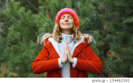 Calm relaxed healthy woman meditates in winter forest, girl practicing doing yoga exercises outdoors 134461591
