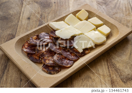sliced salami and cheese on wooden cutting board rustic appetizer 134461743