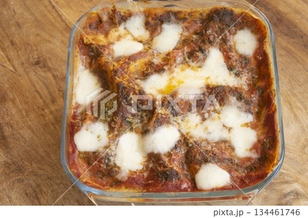 homemade baked pasta with melted mozzarella and meat sauce in dish 134461746