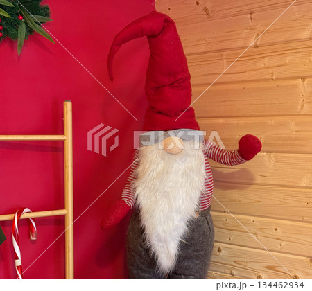 Christmas gnome figure with candy cane and red decor close-up. Scandinavian holiday style, cozy winter interior and festive home decoration. Christmas gnome figure with candy cane and red decor close-up. Scandinavian holiday style, cozy winter interior and festive home decoration. 134462934