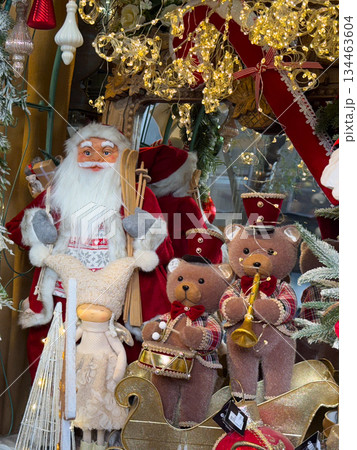 Santa with toy bears and festive ornaments surrounded by winter shop decor. Cozy Christmas spirit, nostalgia, childhood memories and magical celebration atmosphere Santa with toy bears and festive ornaments surrounded by winter shop decor. Cozy Christmas spirit, nostalgia, childhood memories and magical celebration atmosphere 134463604