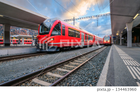 Red modern passenger train on mountain railway station in Alps 134463960