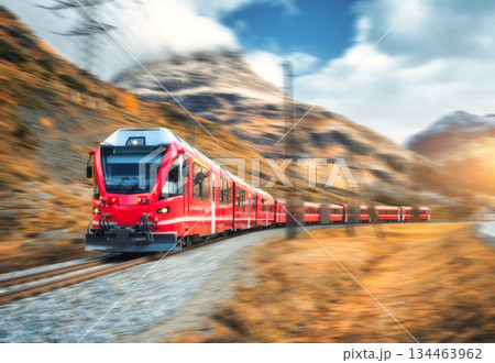 Red modern passenger train is moving on railway in swiss alps 134463962