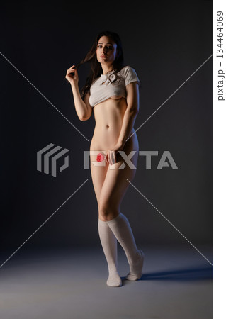 Woman in lingerie elegantly dancing with a rose in a dimly lit studio Woman in lingerie elegantly dancing with a rose in a dimly lit studio 134464069