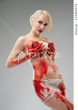 Woman posing in studio with blood bodyart in creative expression Woman posing in studio with blood bodyart in creative expression 134464078