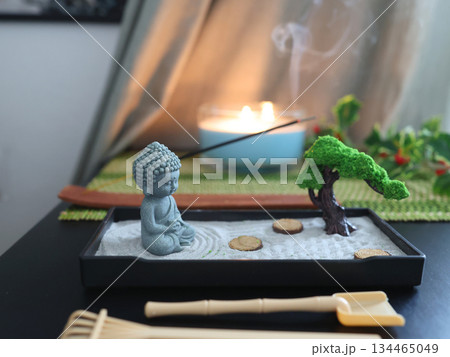 Zen style Buddha statue. Miniature meditation and relaxation set for home on table with incense stick on stand. Eastern rock garden. 134465049