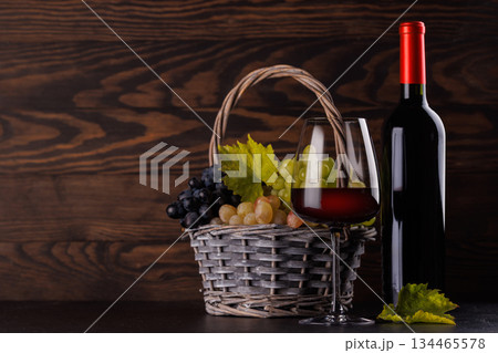 Red wine bottle with a glass and basket of fresh grapes Red wine bottle with a glass and basket of fresh grapes 134465578