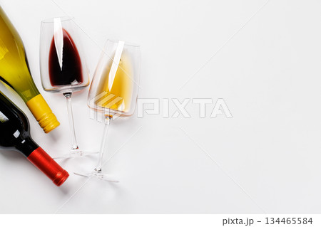 Wine glasses with red and white wine and bottles lying on white background 134465584