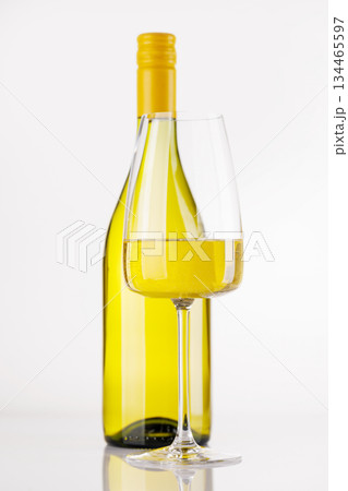 White wine bottle and glass on white background White wine bottle and glass on white background 134465597