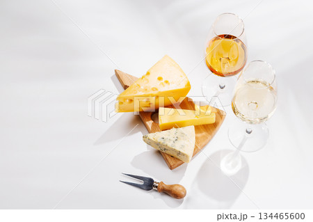 Assorted cheeses and wine glasses on white background Assorted cheeses and wine glasses on white background 134465600