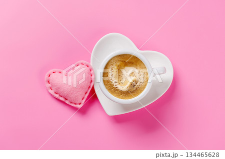Heart-shaped cappuccino cup on pink background Heart-shaped cappuccino cup on pink background 134465628