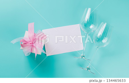 Gift box and wine glasses on blue background Gift box and wine glasses on blue background 134465633