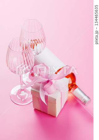 Gift box and wine glasses on pink background Gift box and wine glasses on pink background 134465635