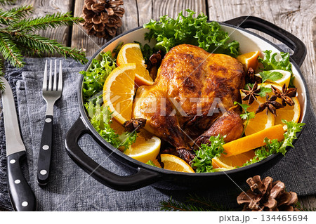 Whole roasted chicken in baking dish with citrus 134465694