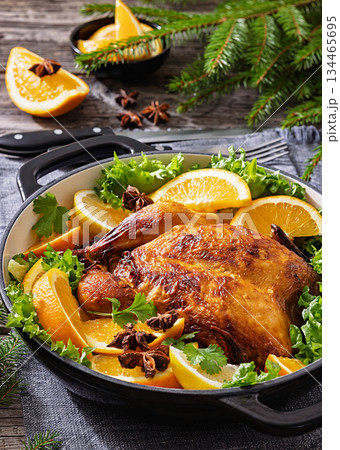 Whole roasted chicken in baking dish with citrus 134465695