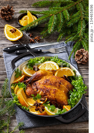Whole roasted chicken in baking dish with citrus 134465696