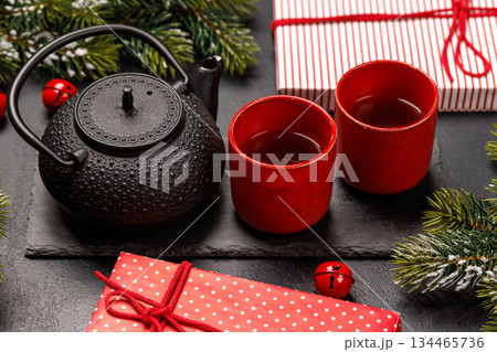 Christmas tea setting with teapot, cups, and fir tree branches 134465736