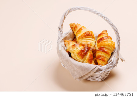 Freshly baked croissants in wicker basket on light background Freshly baked croissants in wicker basket on light background 134465751
